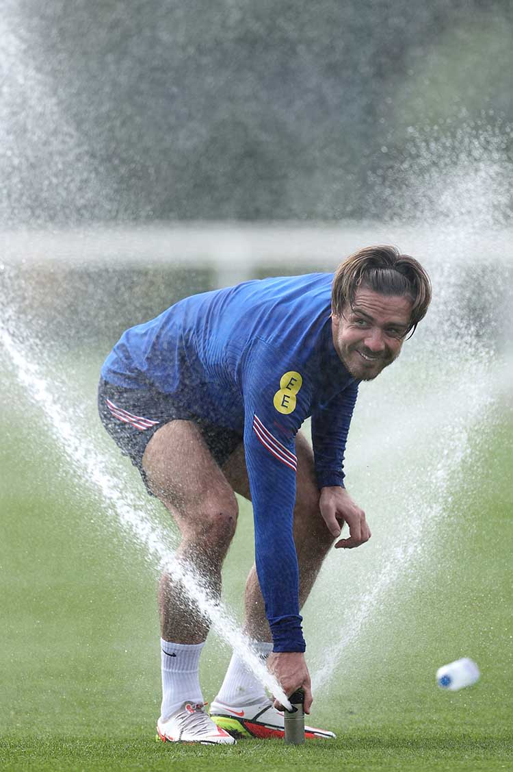 England's Jack Grealish sprays water during training