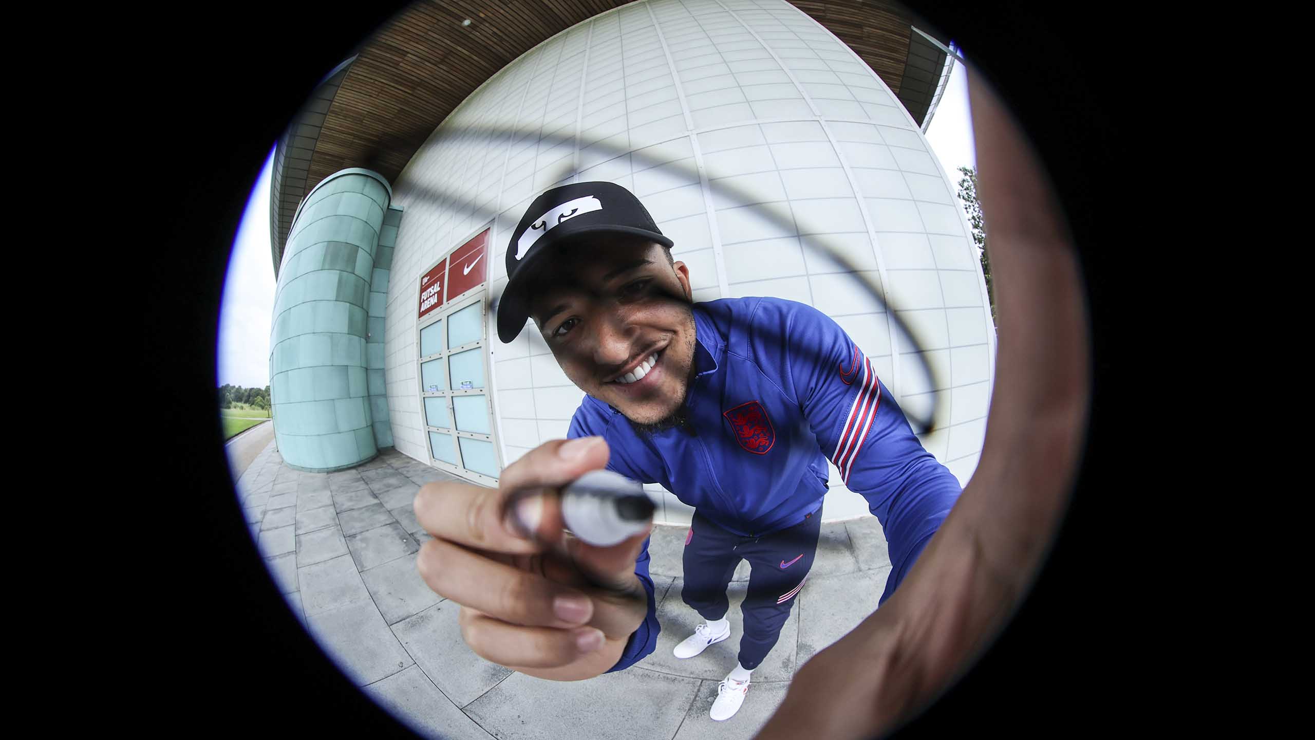 England's Jadon Sancho signs a camera lens during EURO 2020