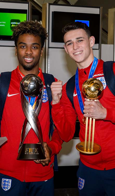 Angel Gomes with the Under-17 World Cup trophy and Phil Foden with the Player of the Tournament award